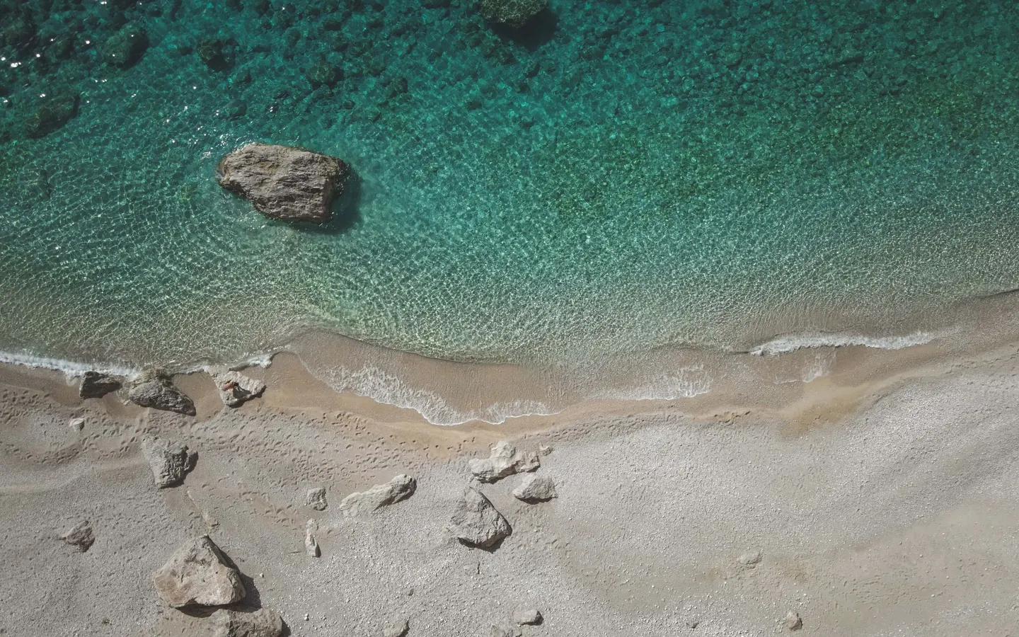Clear turquoise water meeting a pale beach